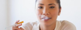 Young woman using e-cigarette: Smokestage Medical Marijuana Blog